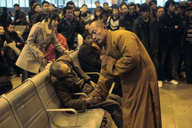 Монах молится за мертвого человека, в зале на железнодорожной станции Шаньси Тайюань.
