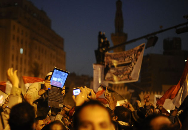 Сторонник оппозиции держит ноутбук, показывая изображение празднований на площади Tahrir г. Каира, Египет.
