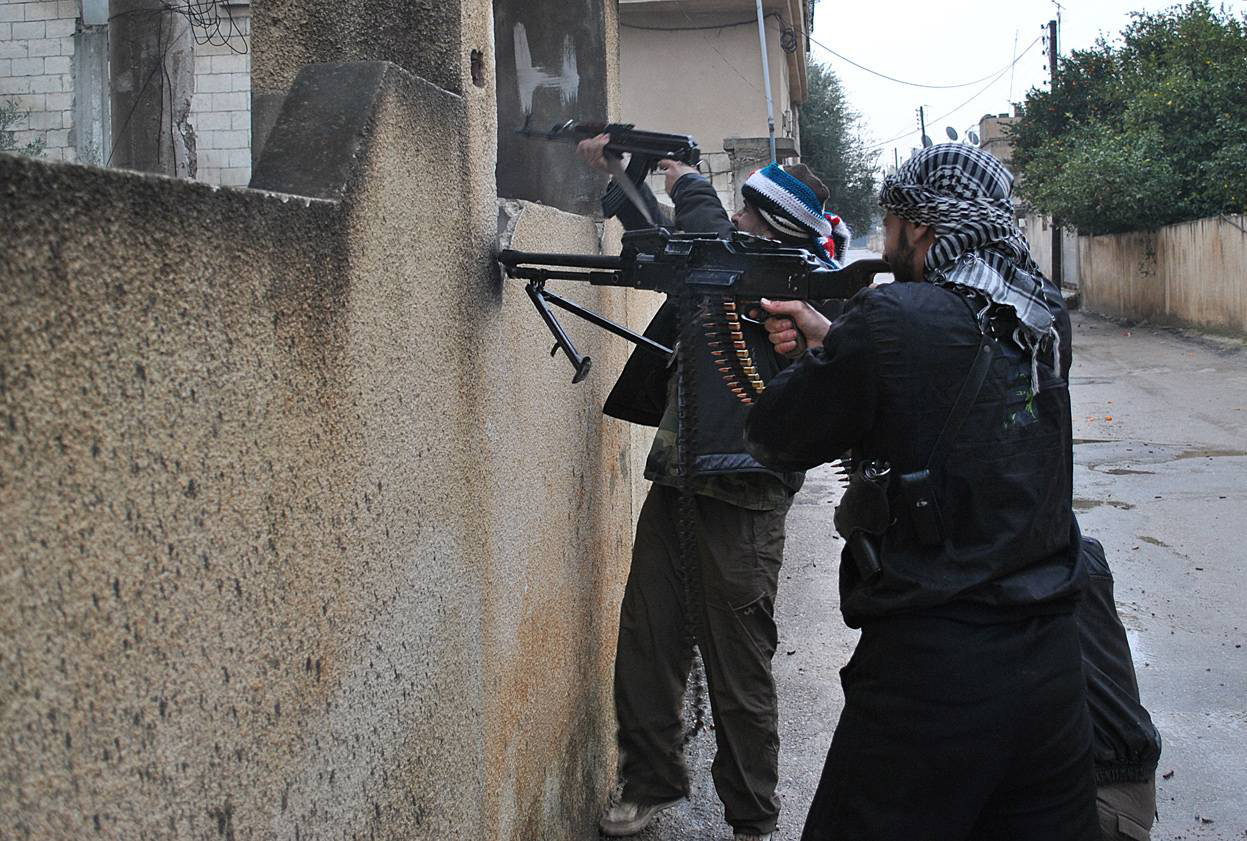 Сирийские «мирные протестанты» заняли позицию под прикрытием стены, ведя бой с правительственными войсками. г. Хомс 31 января 2012 года. AFP Photo